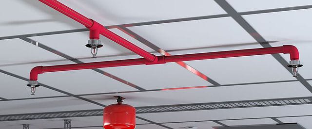 Red fire-sprinkler pipework and suppression tank installed at ceiling level